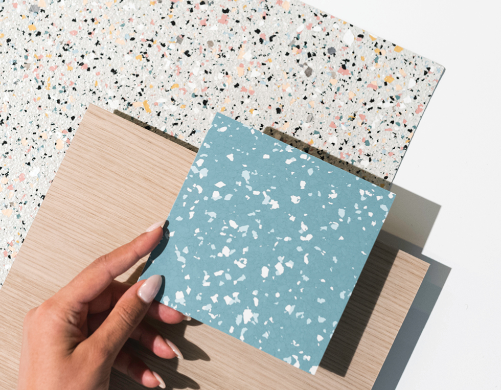 A hand holding resilient floor samples.
